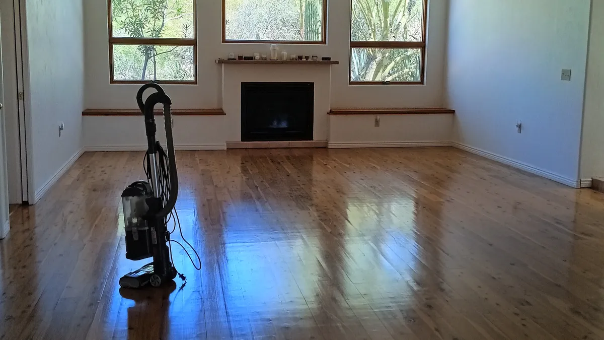 A Tucson living room with freshly cleaned, gleaming wood floors and desert plants outside the windows