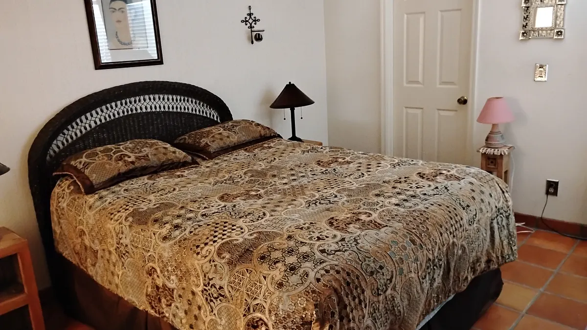 A neatly made bed in a warmly decorated bedroom, the kind of private space a trusted cleaner is welcomed into every visit
