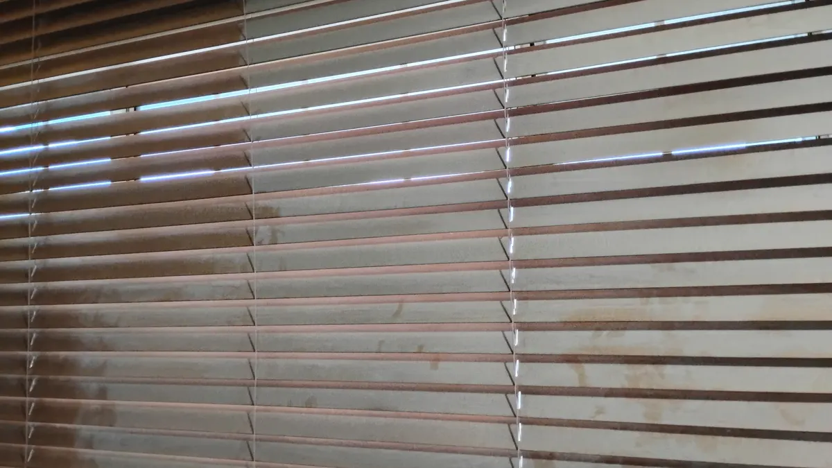 Wooden window blinds coated in fine desert dust from Tucson monsoon season