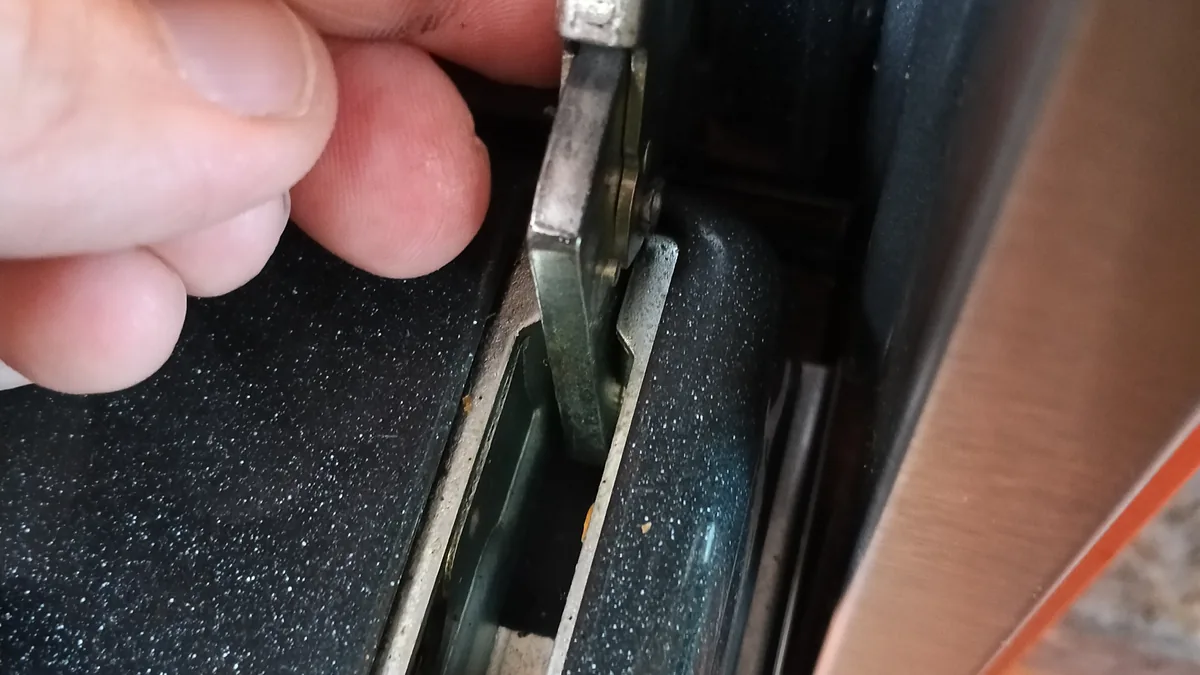 Unlocking an oven door hinge latch to remove the door safely